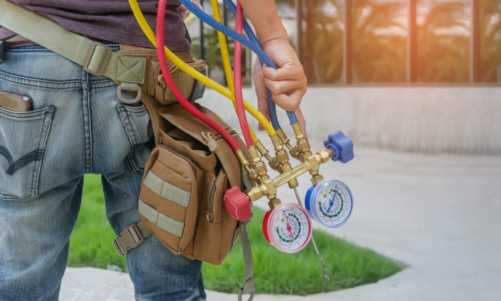 Man's hand holding a manometers on equipment for filling air conditioners.