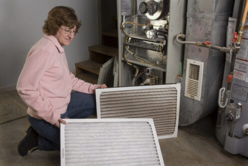 Woman changing the filter on her furnace